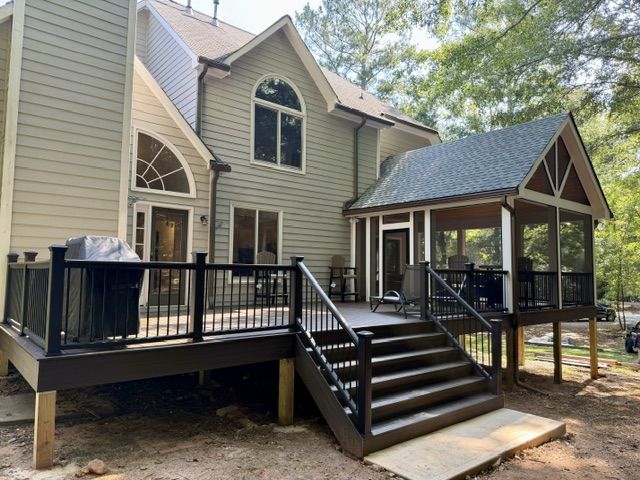 After: new deck with black railing, wide stairs, and a gable-roofed screened porch